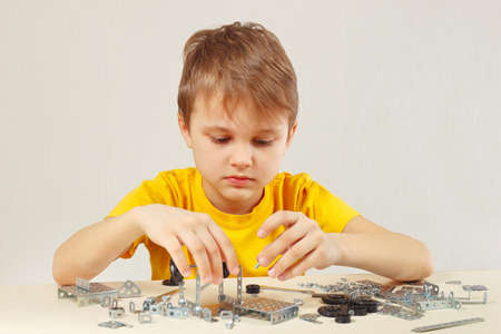 Little engineer plays with mechanical constructor at the tableの写真素材