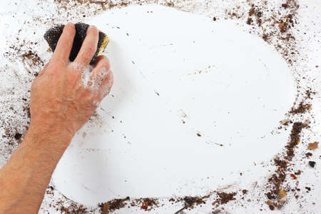 Hand with wet sponge washing a heavily surfaceの写真素材