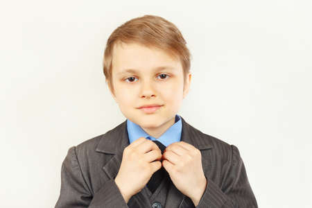Little cute boy straighten collar of his elegant suit