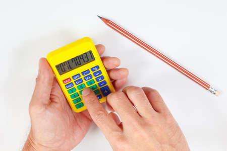 Hands calculate using a pocket digital calculator on a white backgroundの写真素材