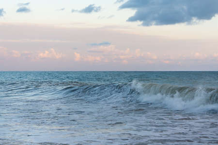 Sea waves against the cloudy sky in the evening before the storm