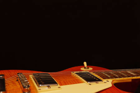 Vintage electric jazz guitar closeup on the black background, with plenty of copy space. Selective...