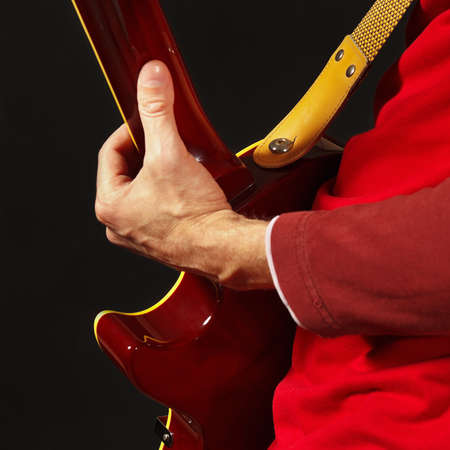 Guitarist playing the guitar on a dark background