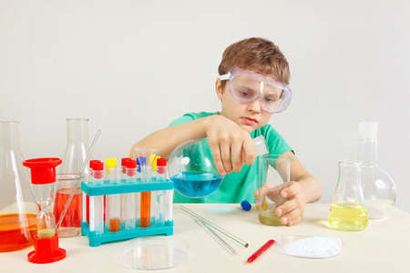 Young smart boy in safety glasses doing chemical experiments in the laboratoryの写真素材