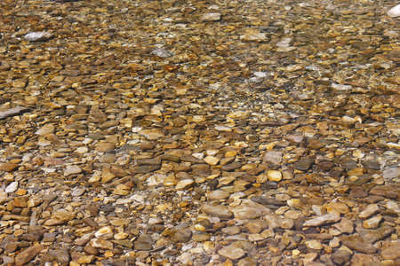 Beautiful sea pebbles under water on the beachの写真素材