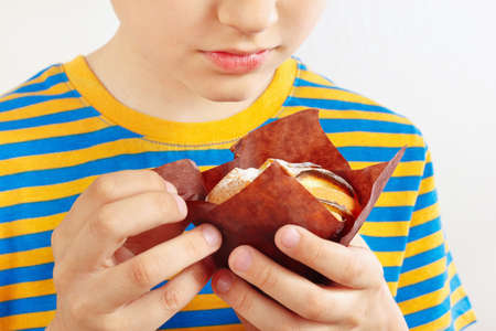 Little cut boy with a appetizing apple muffin on a white background close upの写真素材