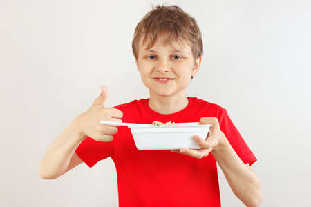 Little cut boy in a red shirt recommends  instant noodles on a white background.の写真素材