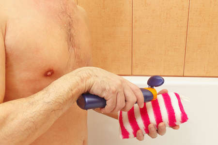 Handsome young man apply gel on a sponge in the bathroomの写真素材