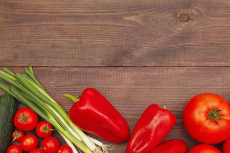 Background of fresh summer vegetables on a wooden table. View from above.の写真素材