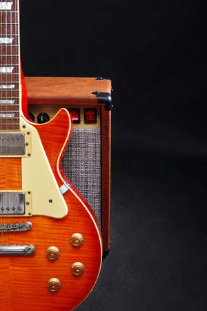 Guitar tube amplifier with guitar on the black background.の写真素材