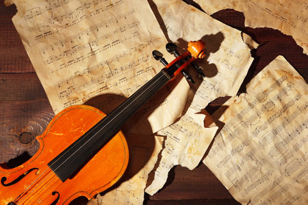 Vintage violin and old sheet music on wooden background close up.の写真素材