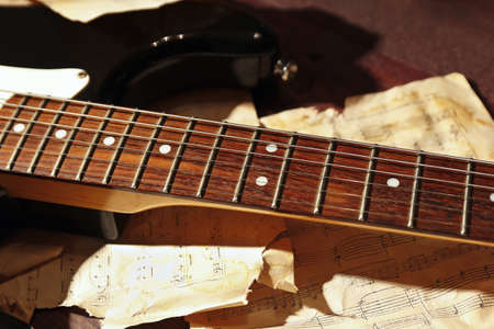 Still life with an electric guitar and old music notes close up.の写真素材