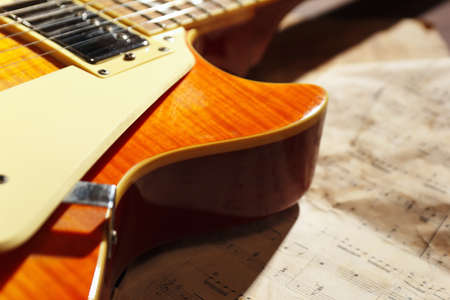 Vintage electric blues guitar and old sheet music close up.の写真素材