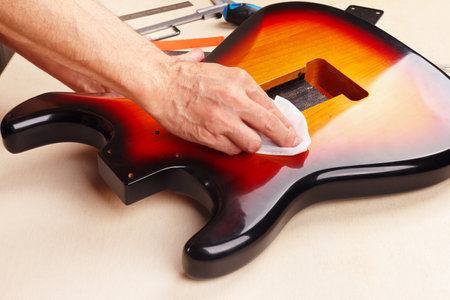 Guitar master polishes the body of electric guitar.の写真素材