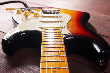 Vintage electric rock guitar closeup on the wooden background. Selective focus.の写真素材