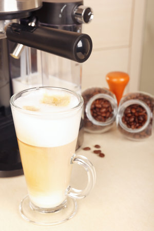 Glass of Irish coffee and cans of coffee beans on the kitchen table.の写真素材