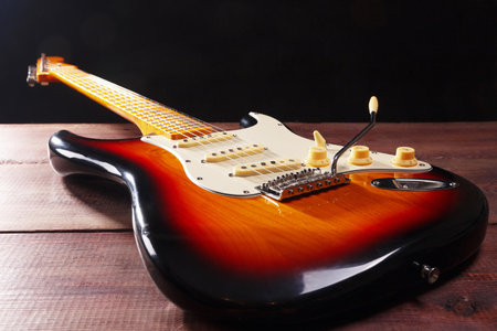 Electric rock guitar closeup on the wooden background. Selective focus.の写真素材