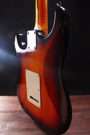 Sunburst electric guitar on the wooden floor. Back view.の写真素材