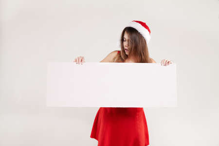 Horizontal portrait of christmas girl with wineglass on white background red dressの写真素材