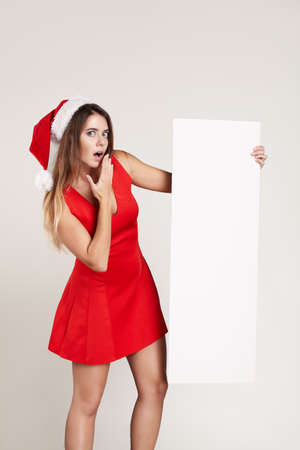 Vertical portrait of christmas girl with wineglass on white background red dressの写真素材