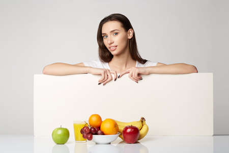 woman beauty girl with fruits basket on gray white backgroundの写真素材