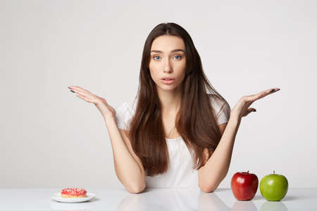 woman beauty girl with fruits and donut apple on gray white backgroundの写真素材