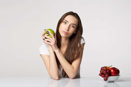 woman beauty girl with fruits and grapes apple on gray white backgroundの写真素材