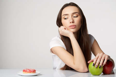 woman beauty girl with fruits and donut apple on gray white backgroundの写真素材