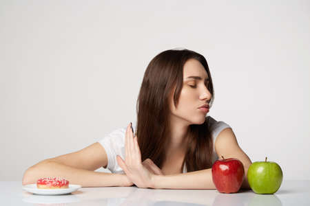 woman beauty girl with fruits and donut apple on gray white backgroundの写真素材