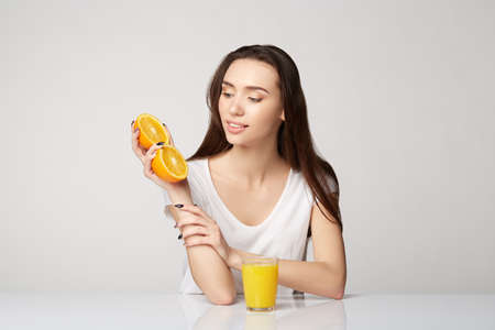 woman girl with fruits oranges on gray white background orangeの写真素材