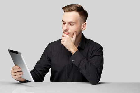 confident man at the table on isolated background with table and phoneの写真素材