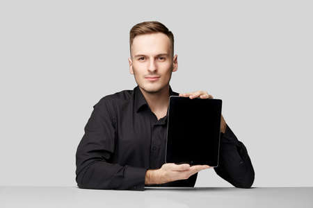 confident man at the table on isolated background with table and phoneの写真素材