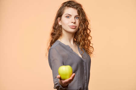 woman with apple biege backgroundの写真素材