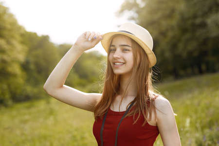 Young girl on nature with hat and binocular. Summerの写真素材