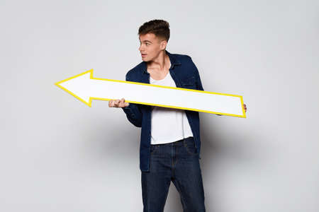 Casual Man holding white arrow on white background at studioの写真素材