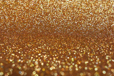 Blurred shining closeup of yellow gold bright art texture. Macro design of classic glittering...