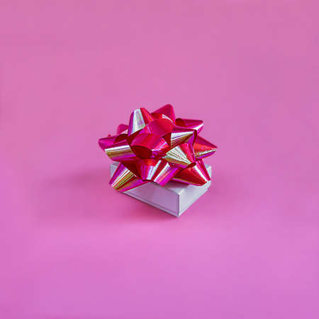 Closeup white gift box on pink background, monochrome postcard, minimalism. Square format, creative instagram background, soft selective focus.の写真素材