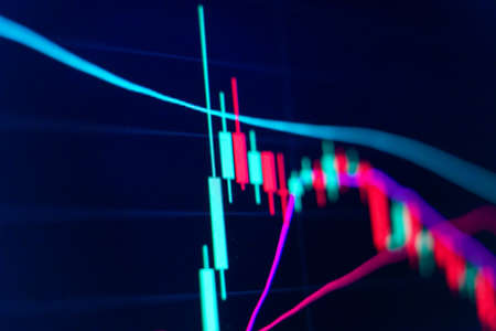 Closeup of financial chart in stock market on blue color monitor background. Downtrend line...