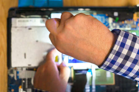 Repair service concept, computer repair shop. Engineer uses screwdriver to repair laptop.の写真素材