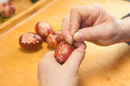 script  hand-decorated dyed easter eggs by scratching patterns using a needleの写真素材