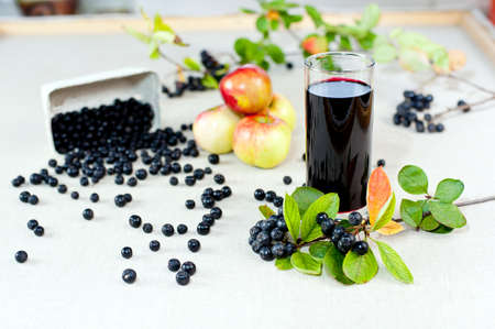 Aronia - Black Choke berry fruits and juice  Separated pile of fruit, twig with leaves, and bunch の写真素材