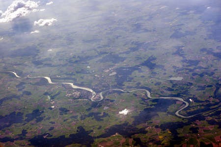Aerial photograph winding river, felds and cloudsの写真素材