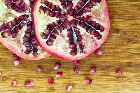 pomegranate fruit slices at wooden deskの写真素材