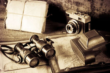 vintage travel memories concept. Old camera, binoculars, letters and map holder with map with vignetteの写真素材