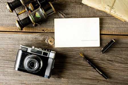 old traveling equipment: camera, binoculars, letters and postard