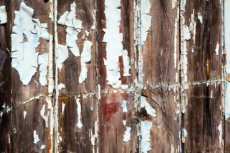 background made of brown, scratched planks with white cracked paintの写真素材