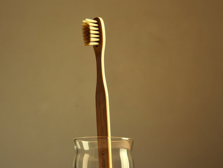 Toothbrush in a glass on a brown background, close-upの素材