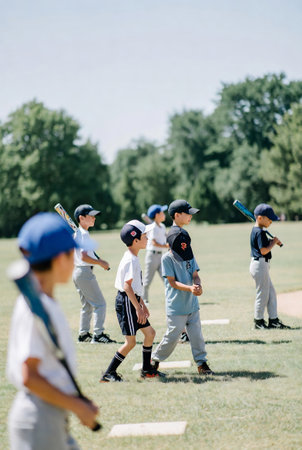 Group of kids playing baseball on the field in summertime. Focus on boyの素材