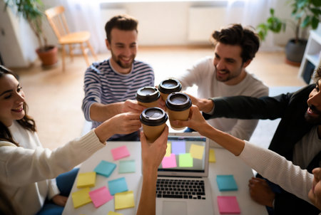 Group of young business people sitting at office desk, drinking coffee.の素材