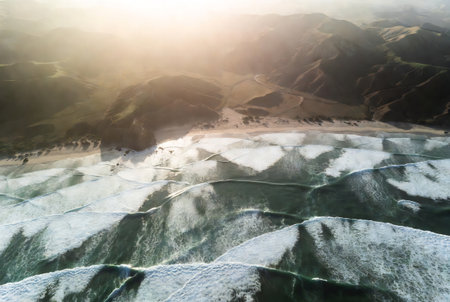 Aerial view of snow-capped mountains and blue lake.の素材